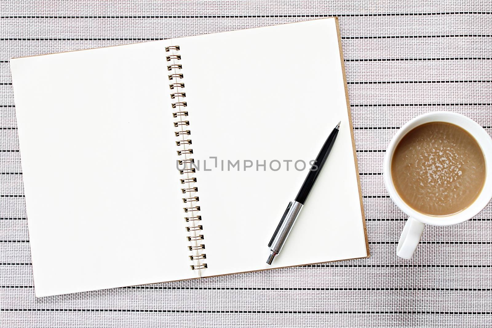 Top view or flat lay image of open notebook with blank pages and coffee cup on table background by sureeporn