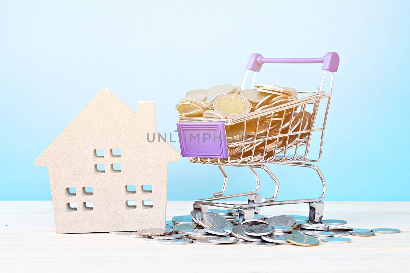Business, finance, saving money, property ladder or mortgage loan concept : Wood house model, coins and shopping cart on desk table