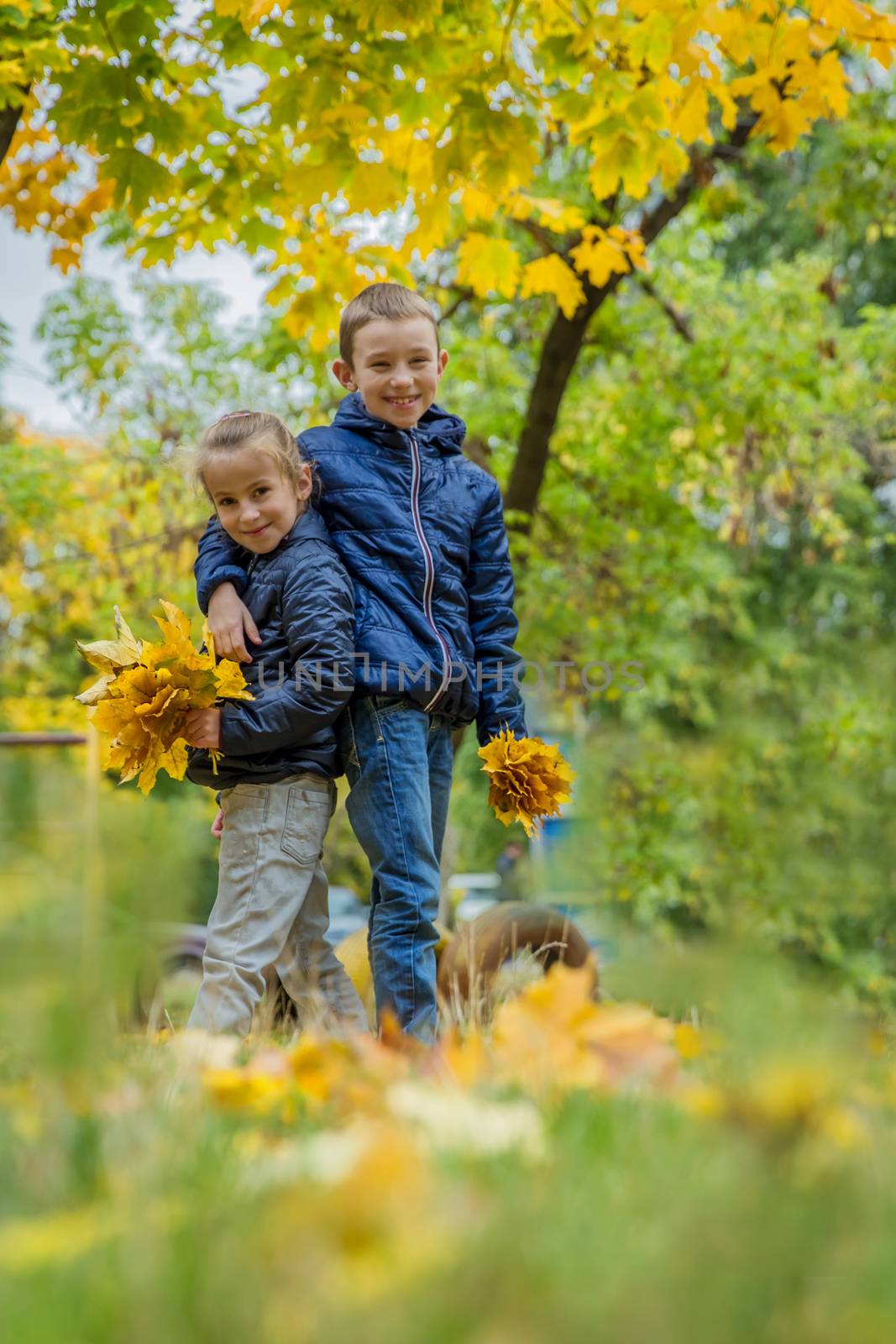 Sister and brother hugging among autumn forest