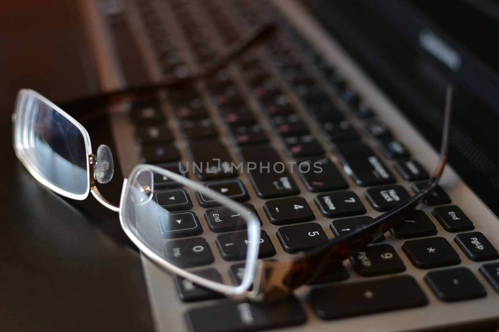 Close-ups on glasses on laptop - office life. Glasses on the laptop's keyboard. Close up.