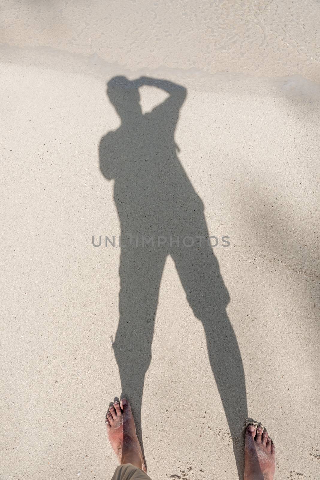 shadow of a photographer on the sand of a tropical beach