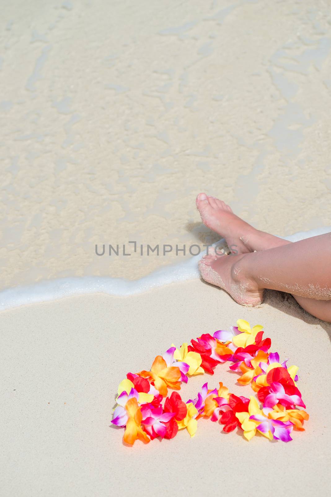 sea wave, female feet and floral Hawaiian beads on the ocean sho by kosmsos111