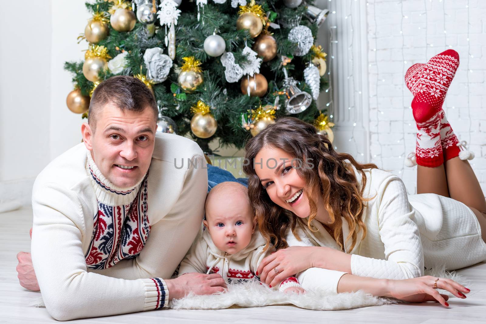 family with son near New Year's fir tree posing and lying on the by kosmsos111