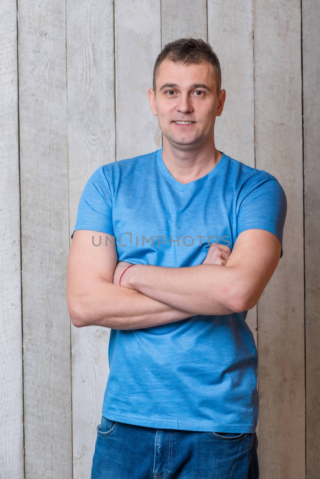 portrait of a man in a blue T-shirt on a wooden background close-up