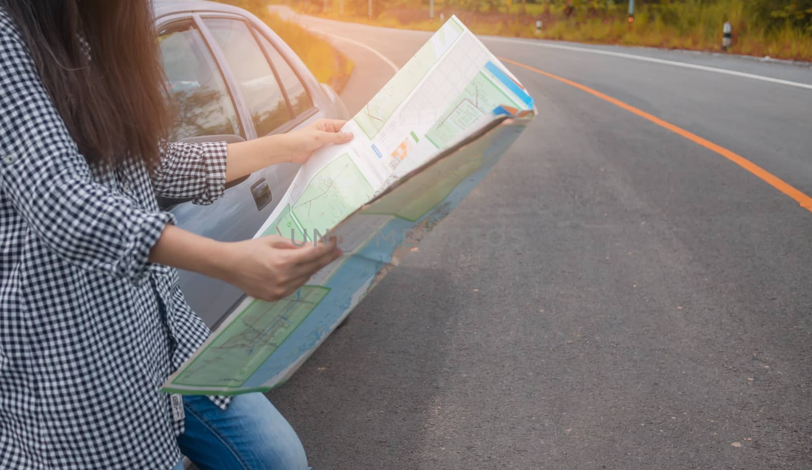 Hipster Asian woman backpacker look map on trip