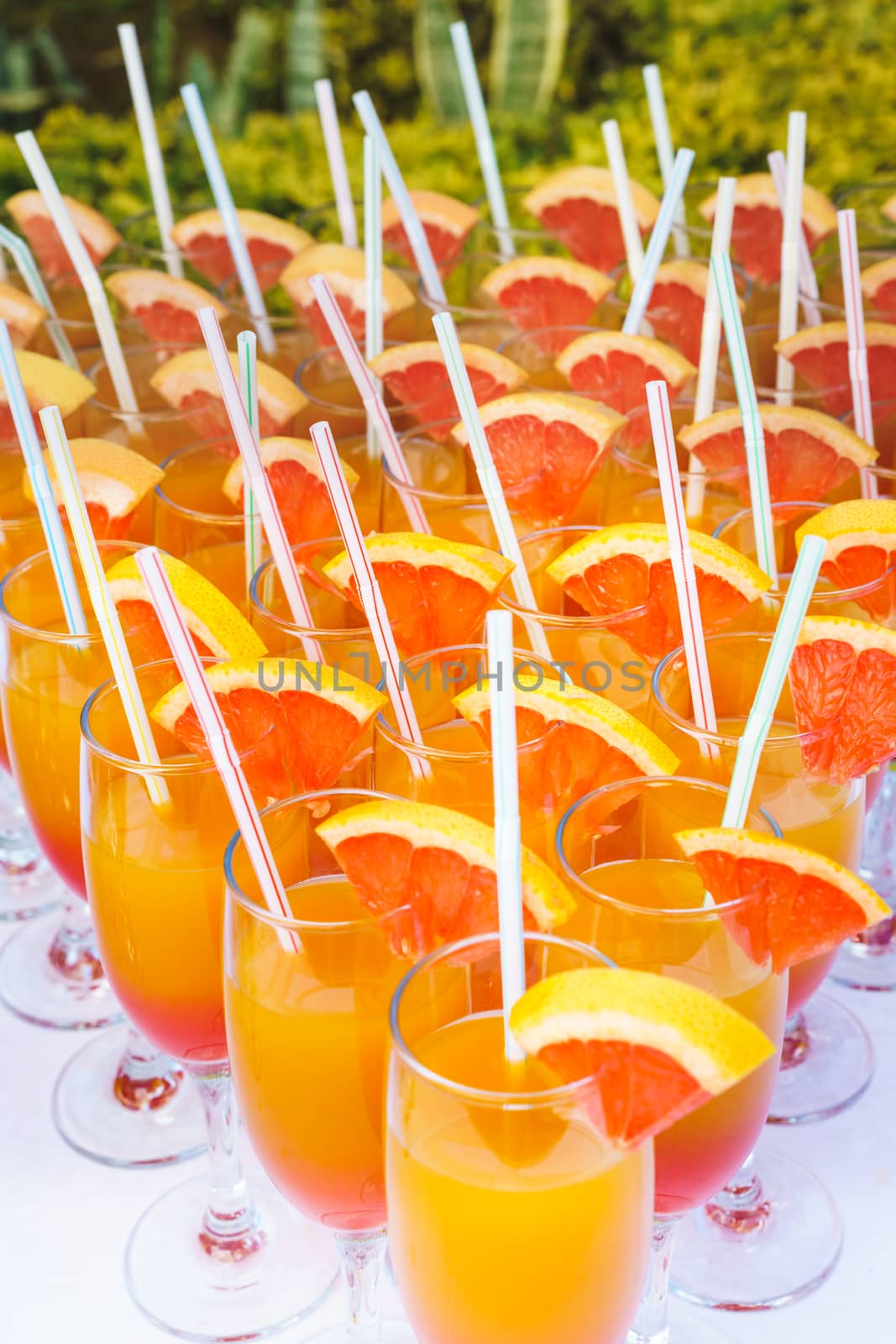 Orange juice cocktail in a flute glasses and slice of fresh orange with draw on white table,closed picture.