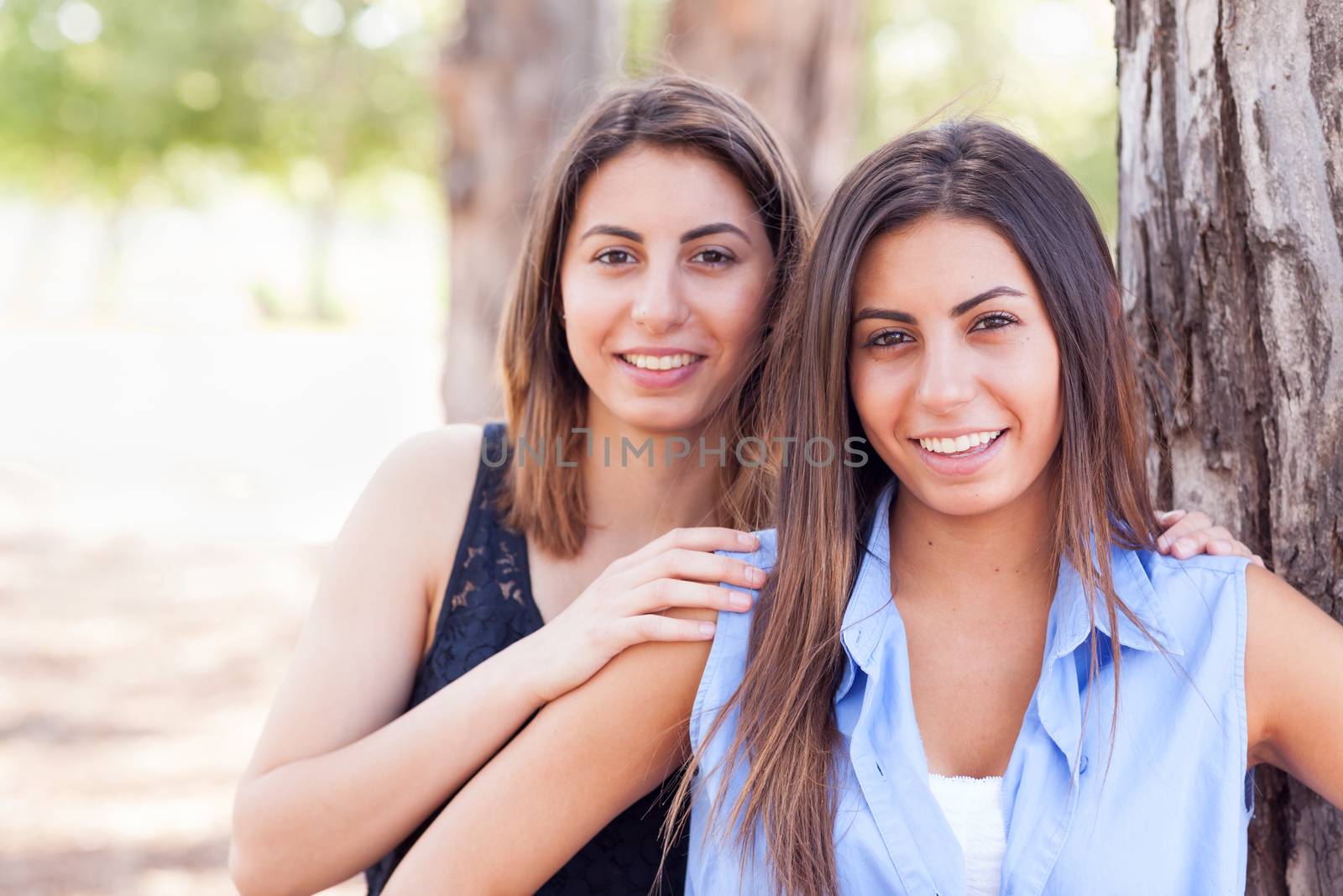 Two Beautiful Ethnic Twin Sisters Portrait Outdoors. by Feverpitched
