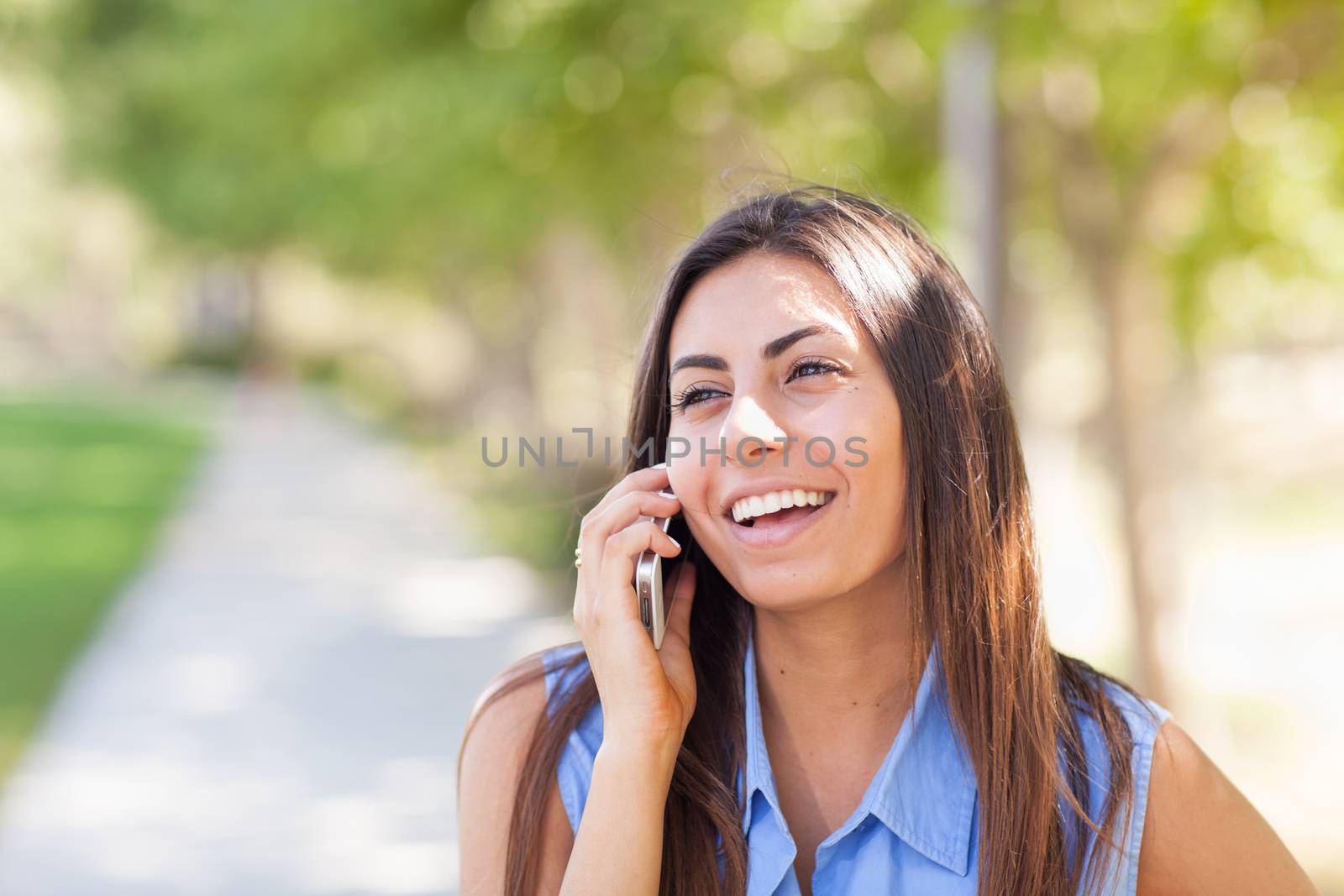 Beautiful Young Ethnic Woman Talking on Her Smartphone Outside.