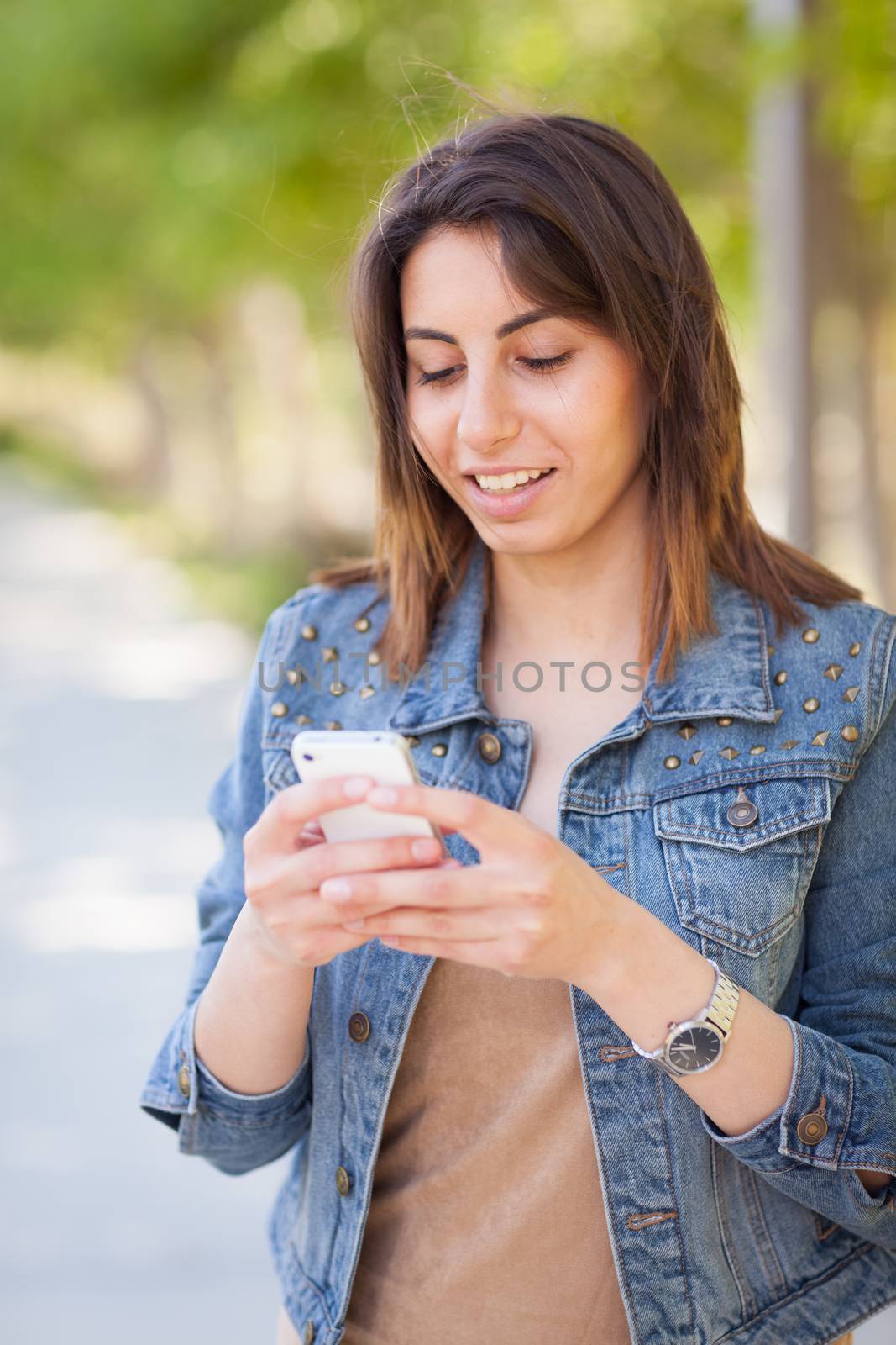 Beautiful Young Ethnic Woman Using Her Smartphone Outside. by Feverpitched