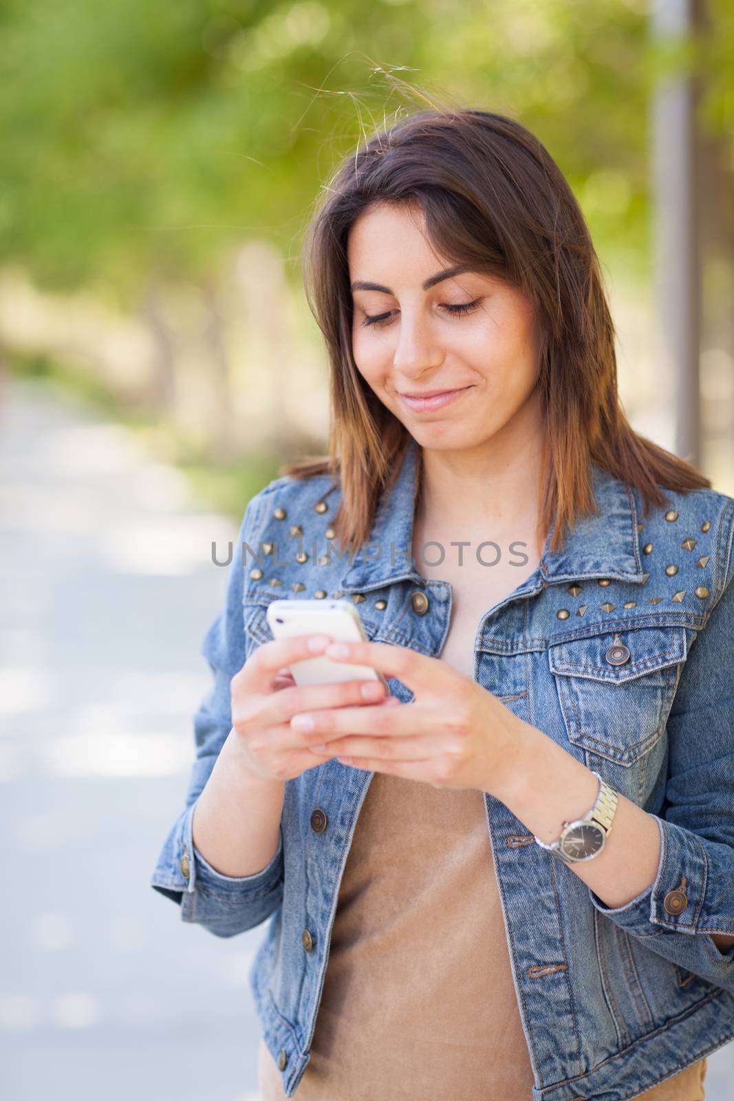 Beautiful Young Ethnic Woman Using Her Smartphone Outside. by Feverpitched