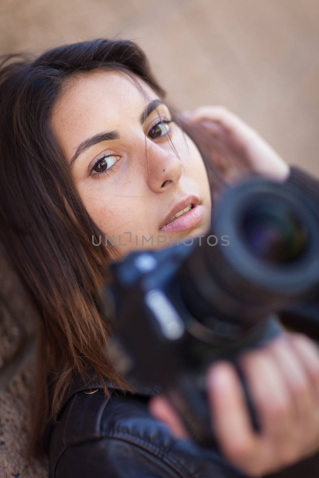 Young Adult Ethnic Female Photographer Against Wall Holding Camera. by Feverpitched