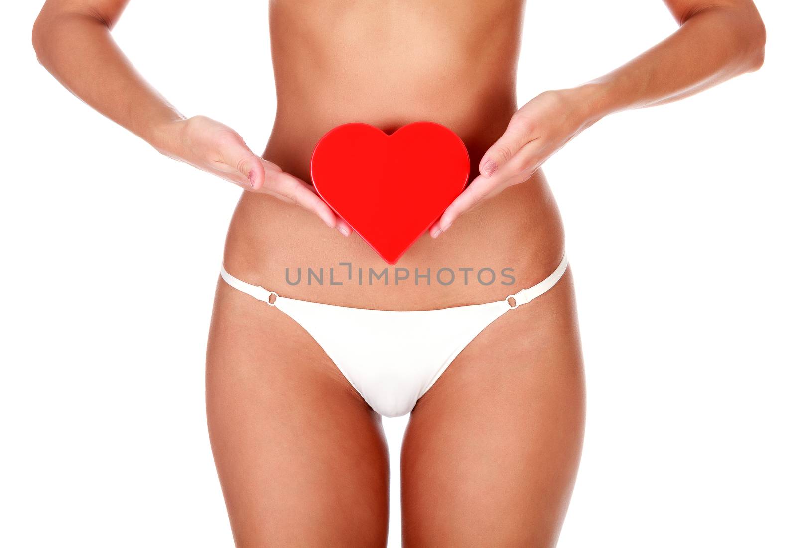 Woman with slim body and healthy skin holds a red plastic heart, isolated on white background