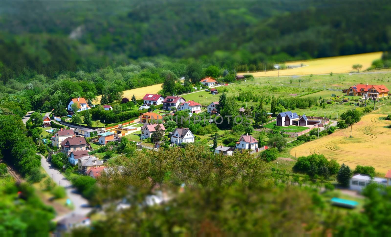 Beautiful village with houses in valley shot with tilt shift effect.