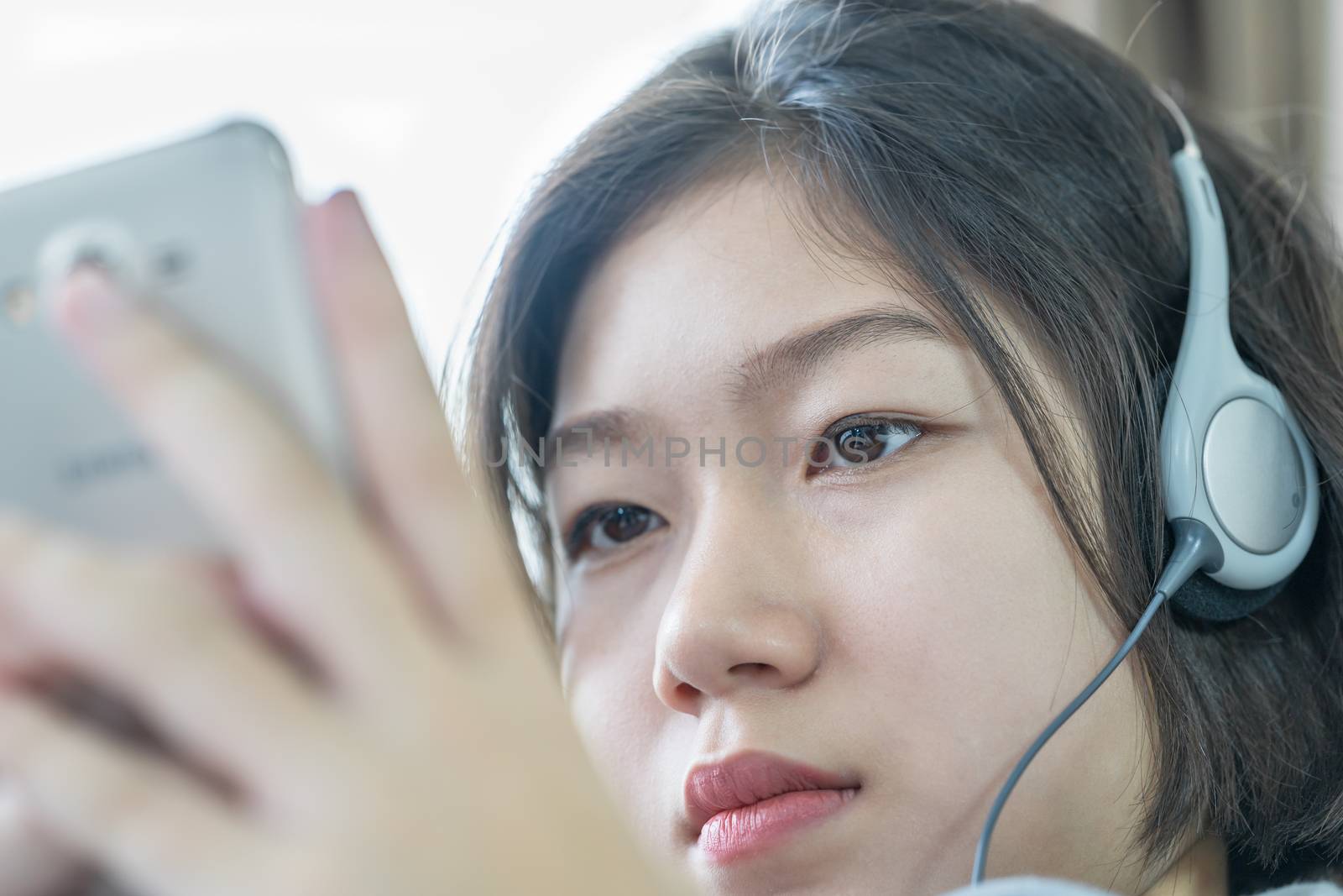 Asian woman listening music from mobile phone by stoonn