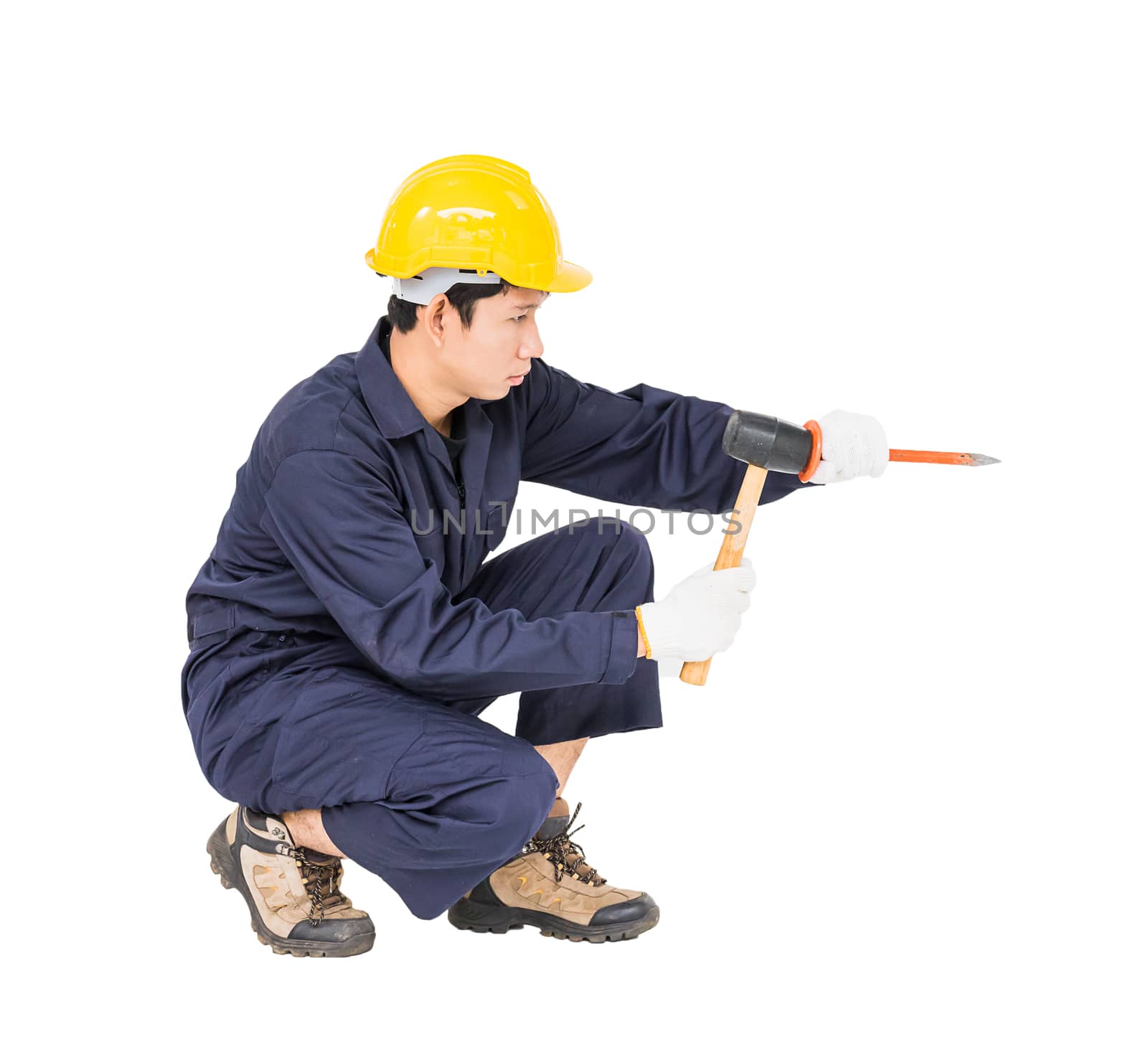 Young man in uniform sit and holding hammer was nailed to a cold chisel, Cut out isolated on white background