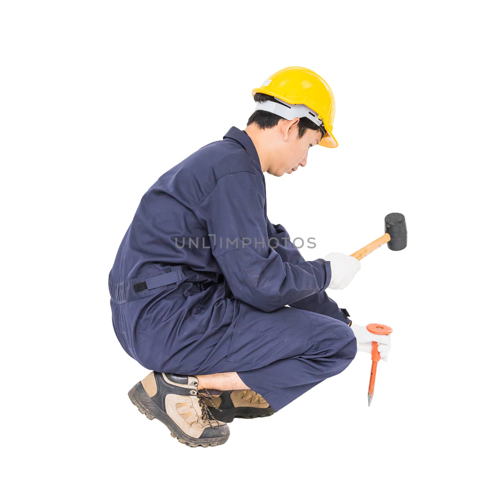 Young man in uniform sit and holding hammer was nailed to a cold chisel, Cut out isolated on white background