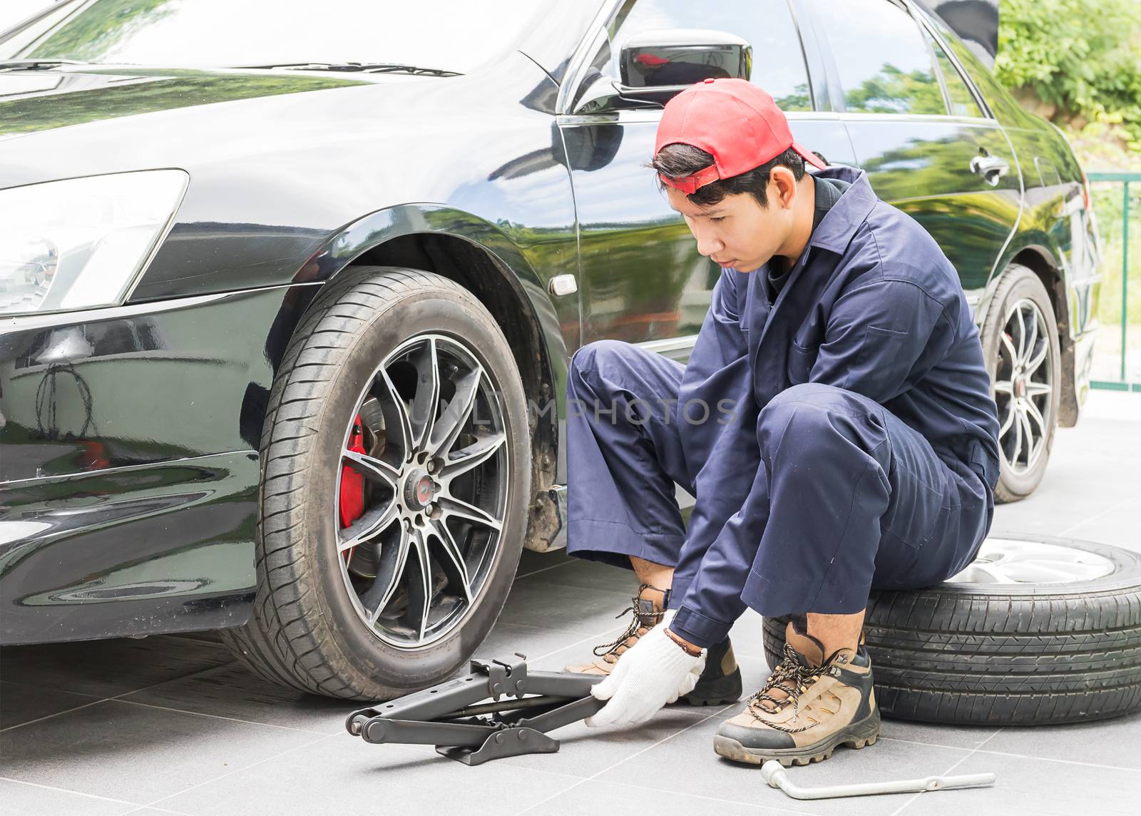 Mechanic replacing lug nuts changing tires on vehicle by stoonn