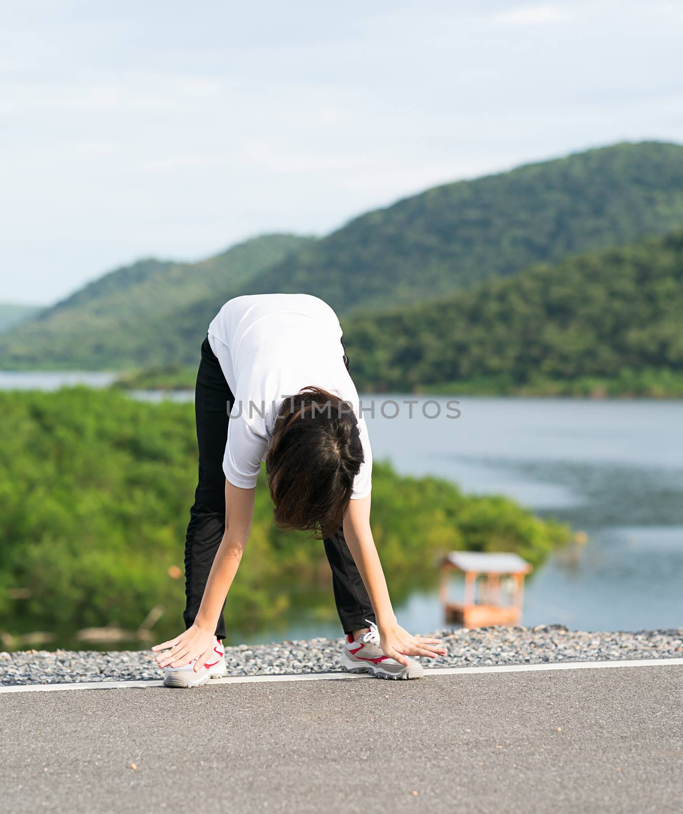 Woman doing exercising and warm up outdoor by stoonn