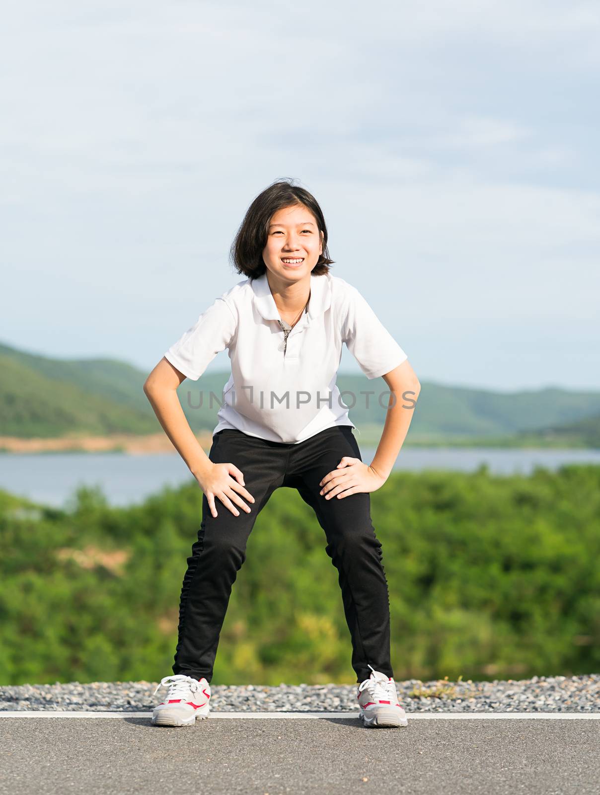 Fitness and lifestyle concept - Young asian woman short hair doing exercising outdoor and warm up preparing for jogging