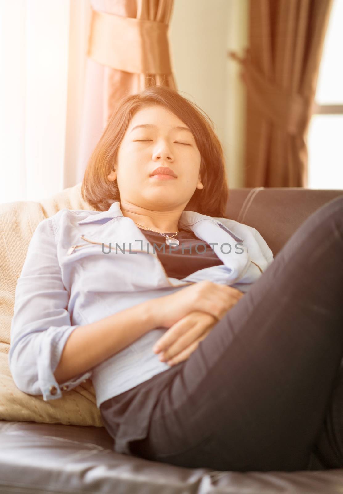 Close up beautiful young asian woman short hair relaxation by side the window in living room at home