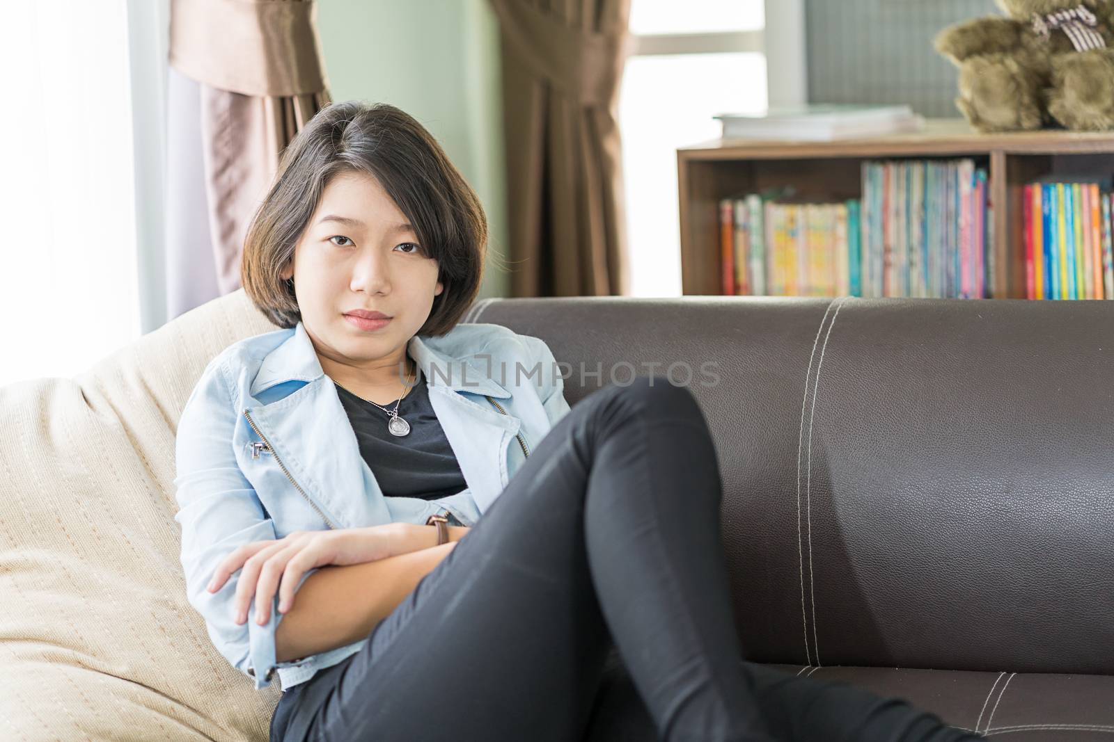 Close up beautiful young asian woman short hair relaxation by side the window in living room at home