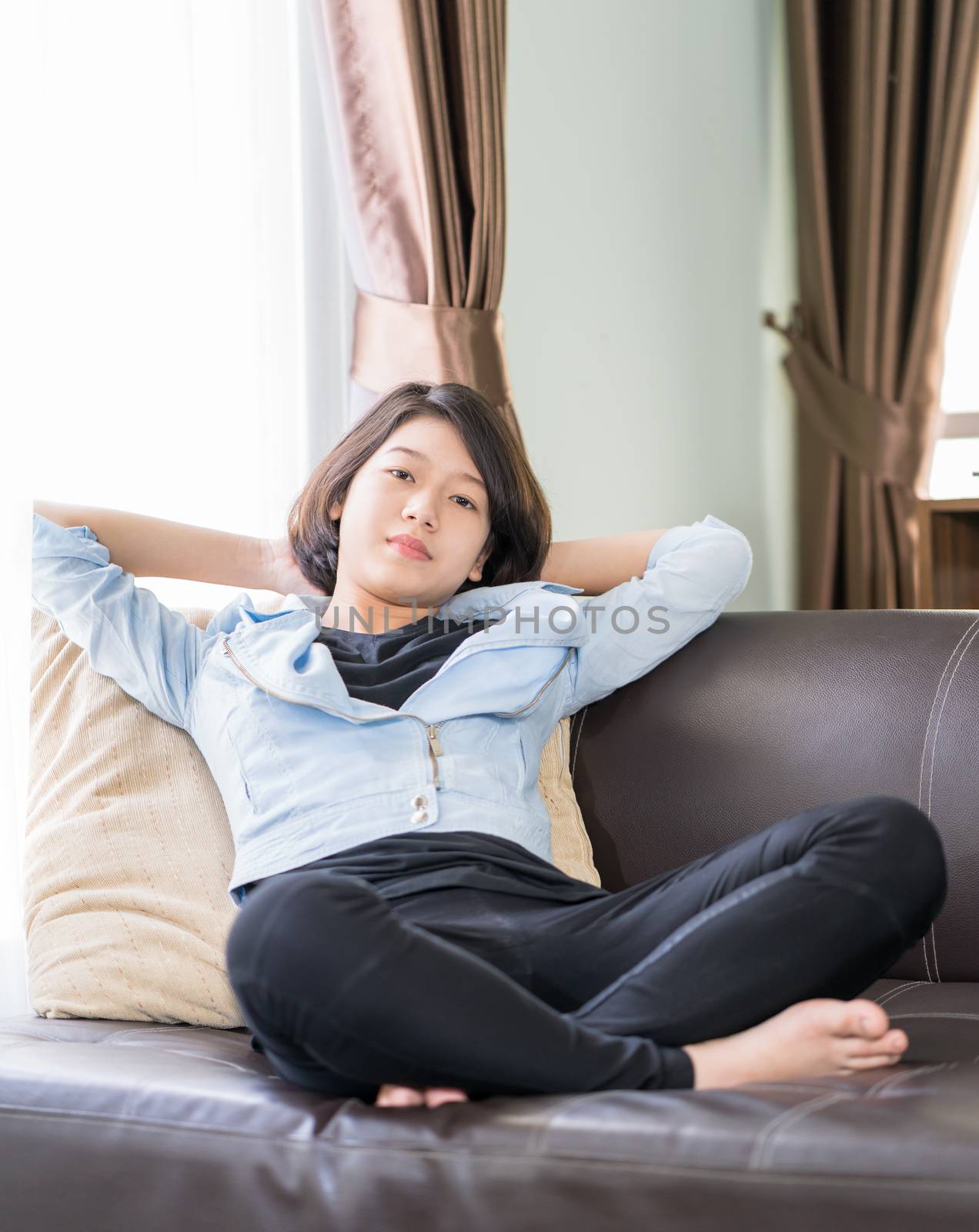 Close up beautiful young asian woman short hair relaxation by side the window in living room at home