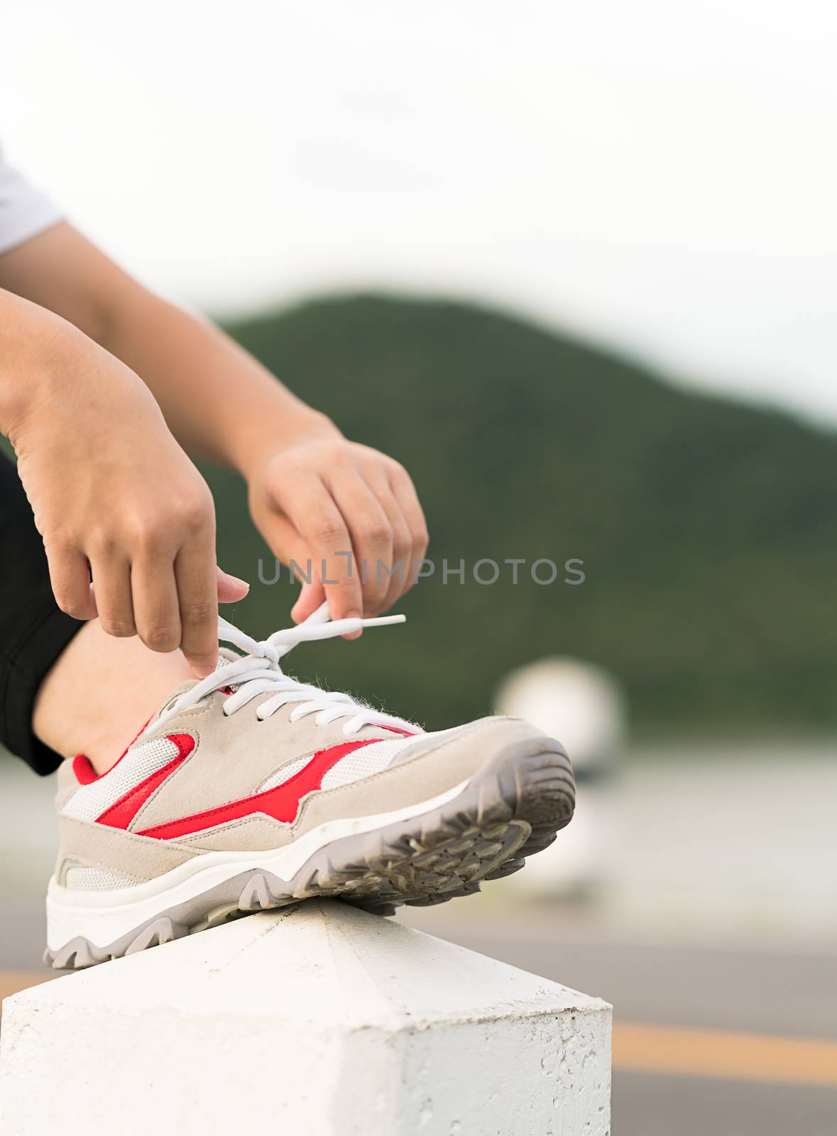 Woman tying shoelace his before starting running by stoonn