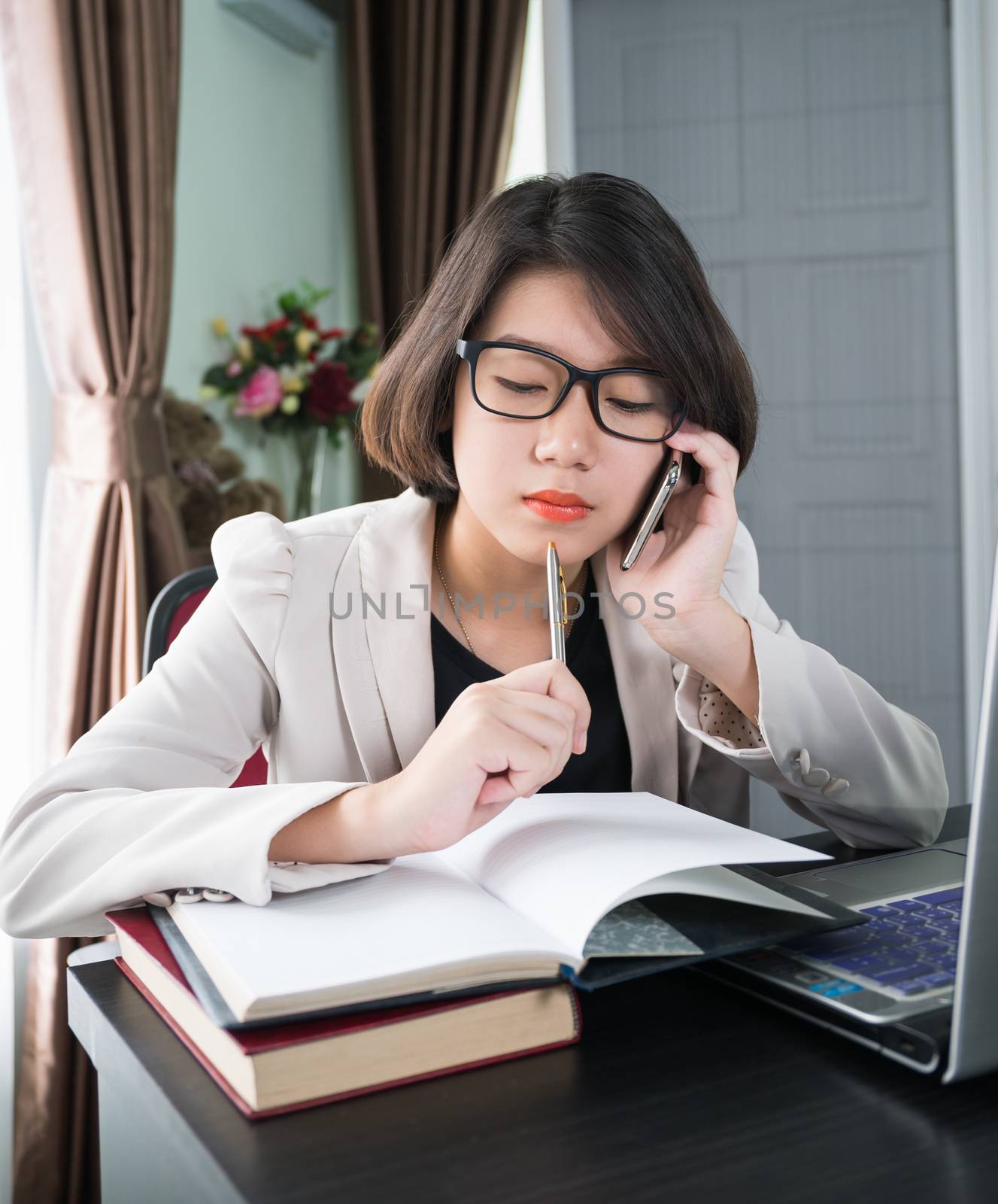 Woman working on laptop in home office by stoonn