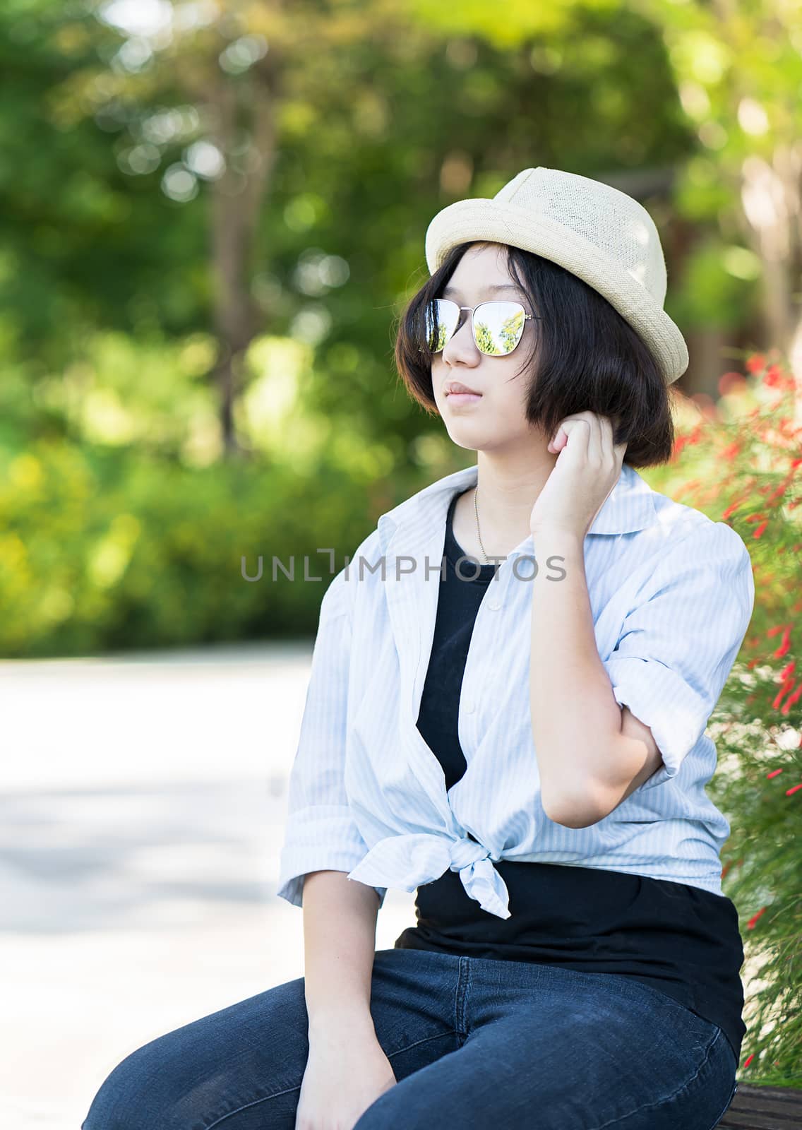 Beautiful and young women with short hair wearing hat in park