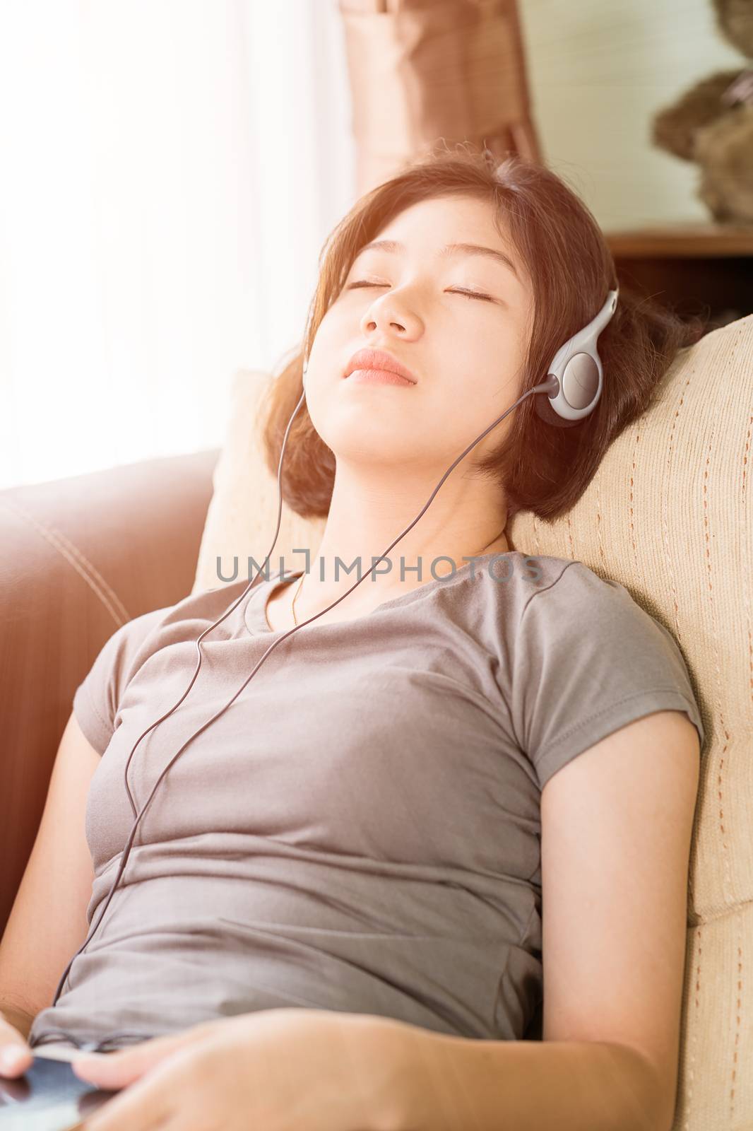 Young woman listening music from mobile phone by stoonn