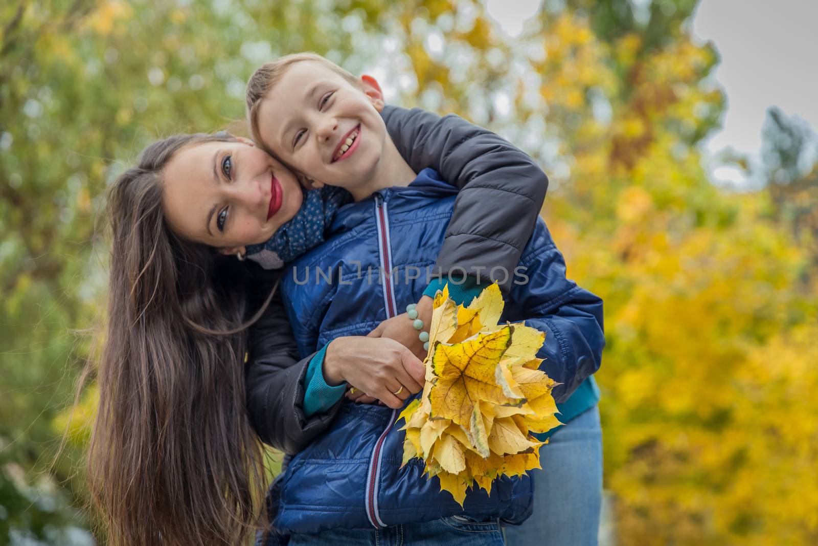 Happy mother hugging son in autumn