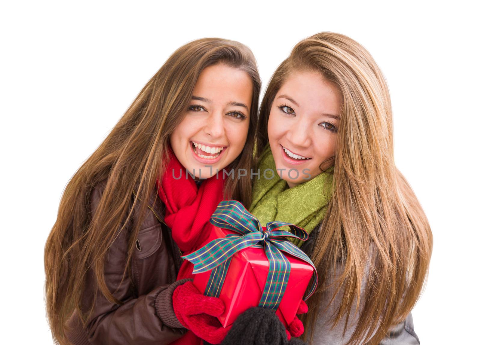 Mixed Race Young Adult Females Holding A Christmas Gift Isolated on a White Background. by Feverpitched