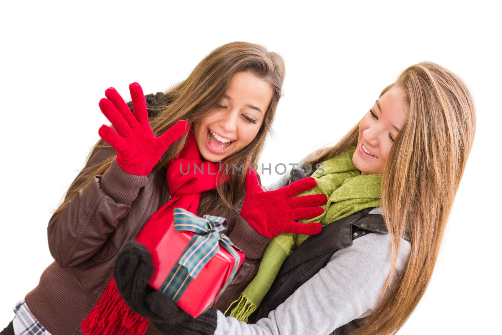 Mixed Race Young Adult Females Holding A Christmas Gift Isolated on a White Background. by Feverpitched