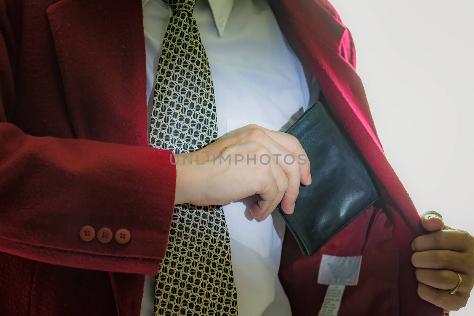 A business man taking out his wallet from suit pocket.