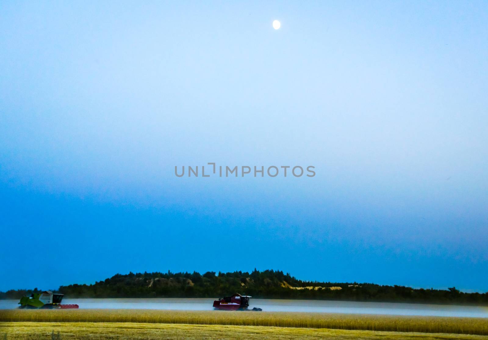 machine harvest wheat field, night moon mountains