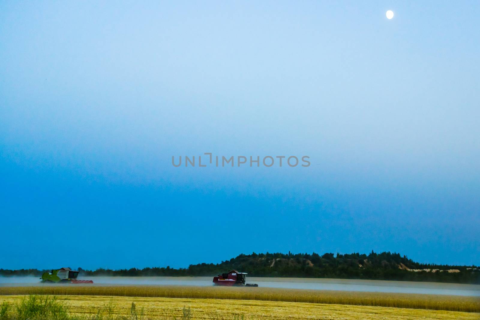 machine harvest wheat field, night moon mountains