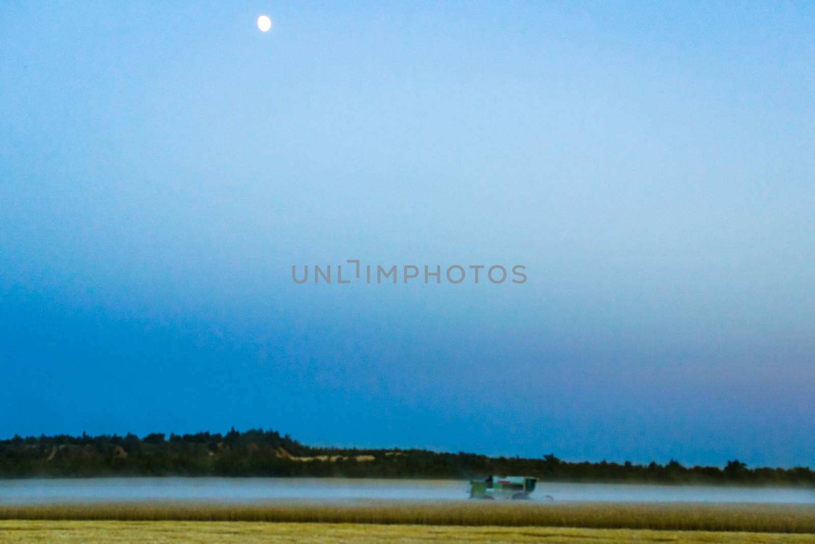 machine harvest wheat field, night moon mountains