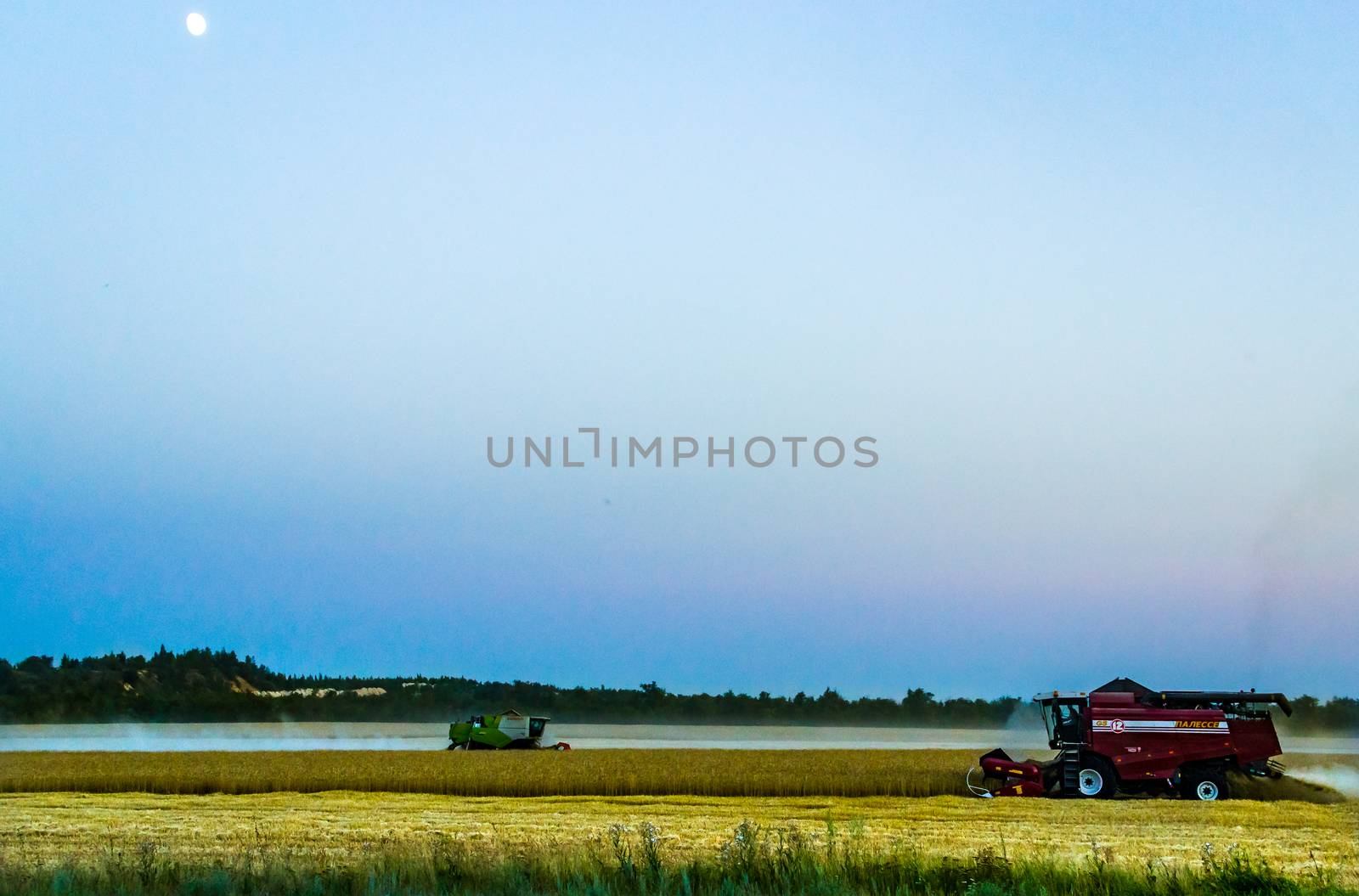 machine harvest wheat field, night moon mountains