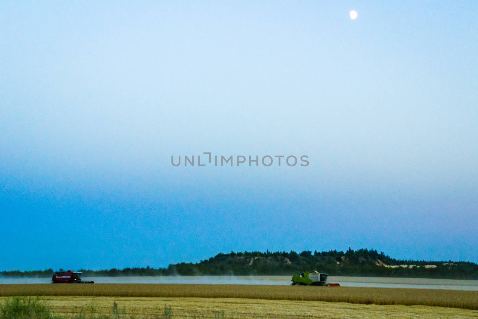 machine harvest wheat field, night moon mountains