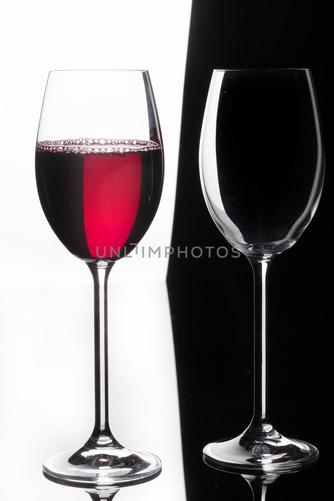 Glass with a red wine on a glass studio background