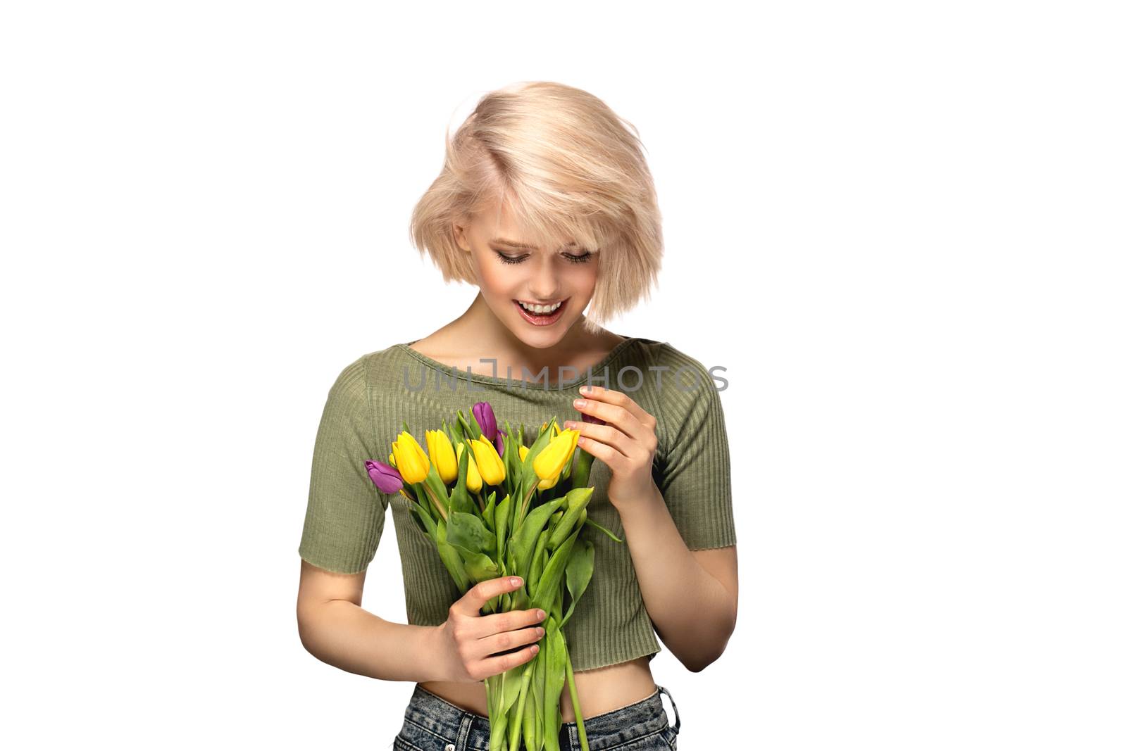 Woman smiling holding bouquet of tulip flowers, studio portrait isolated on white background