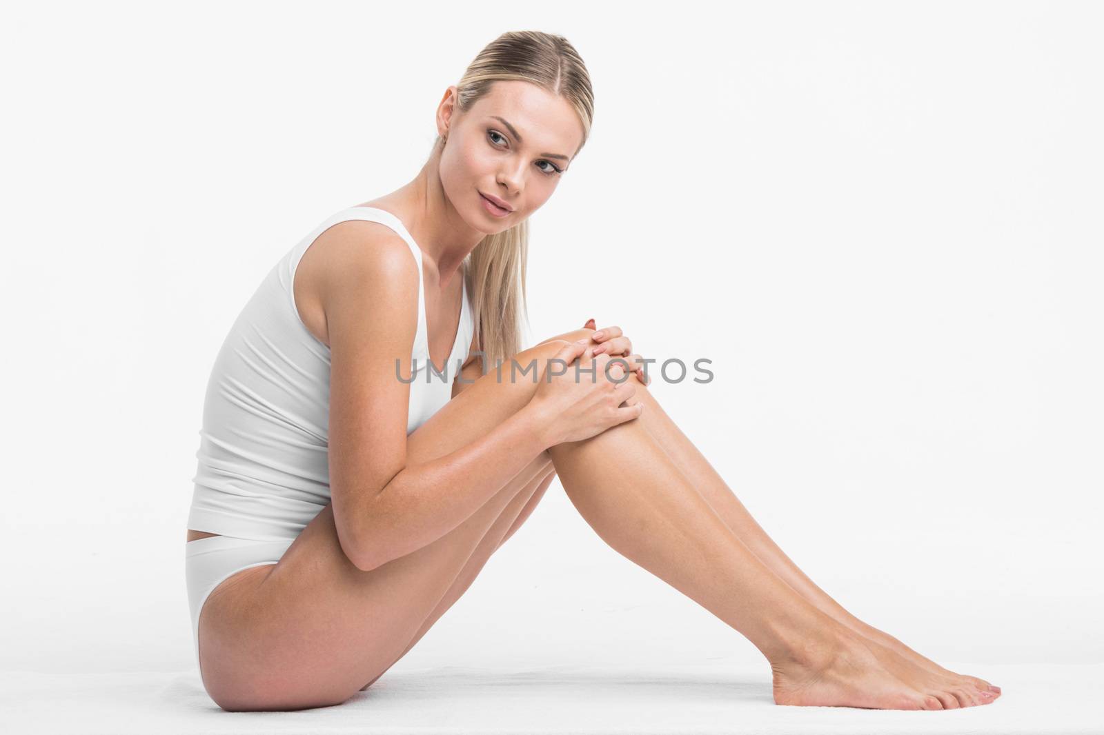 Young beautiful woman in white cotton underwear sitting isolated on white background