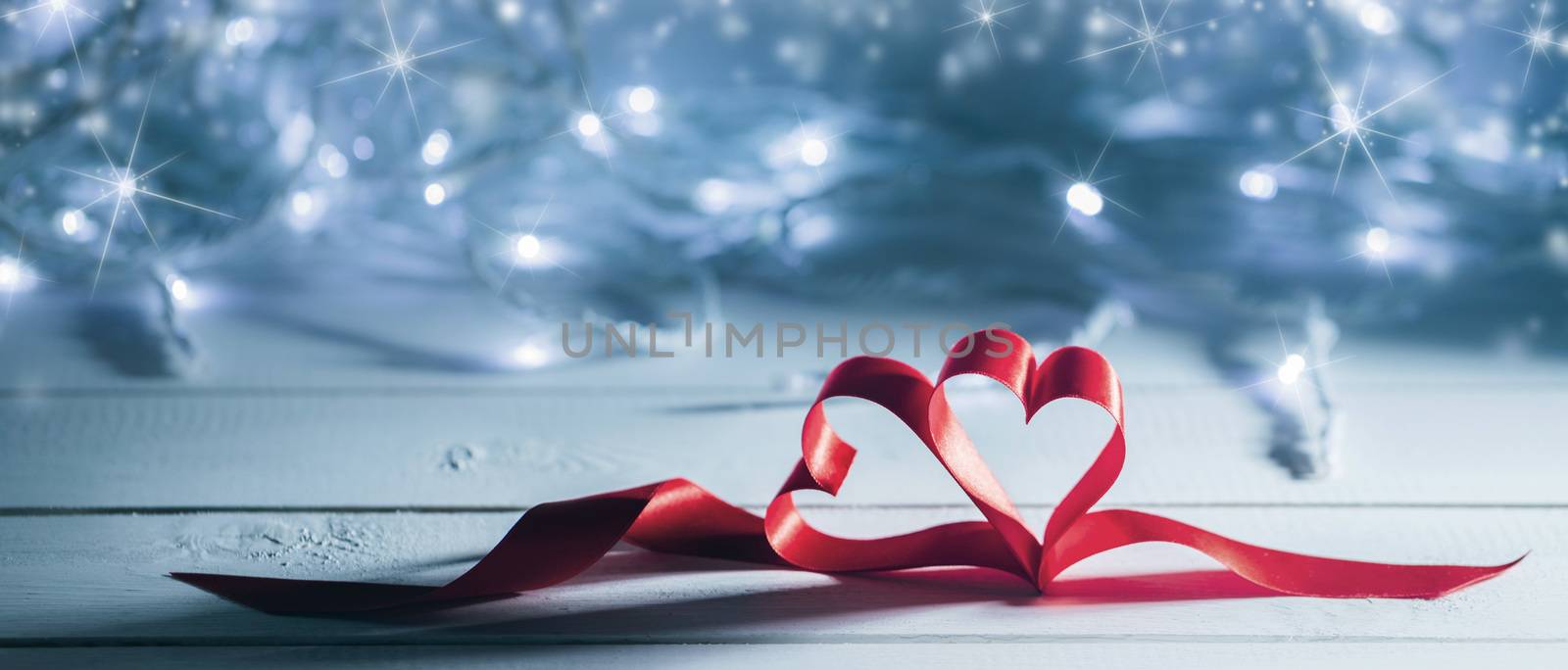 Valentines day ribbon hearts on glowing garland defocused bokeh lights background