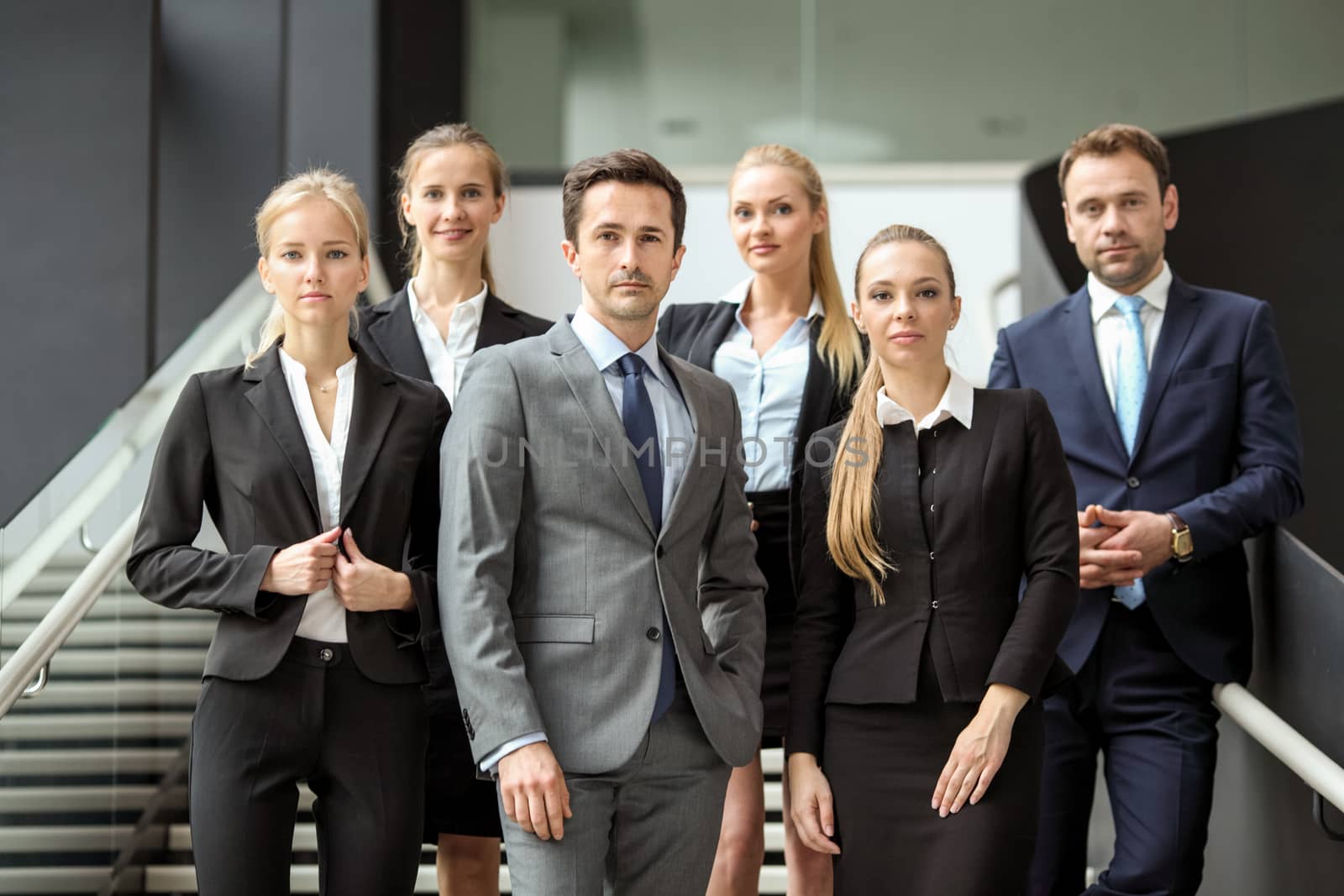 Portrait of successful business people team standing together in modern office building