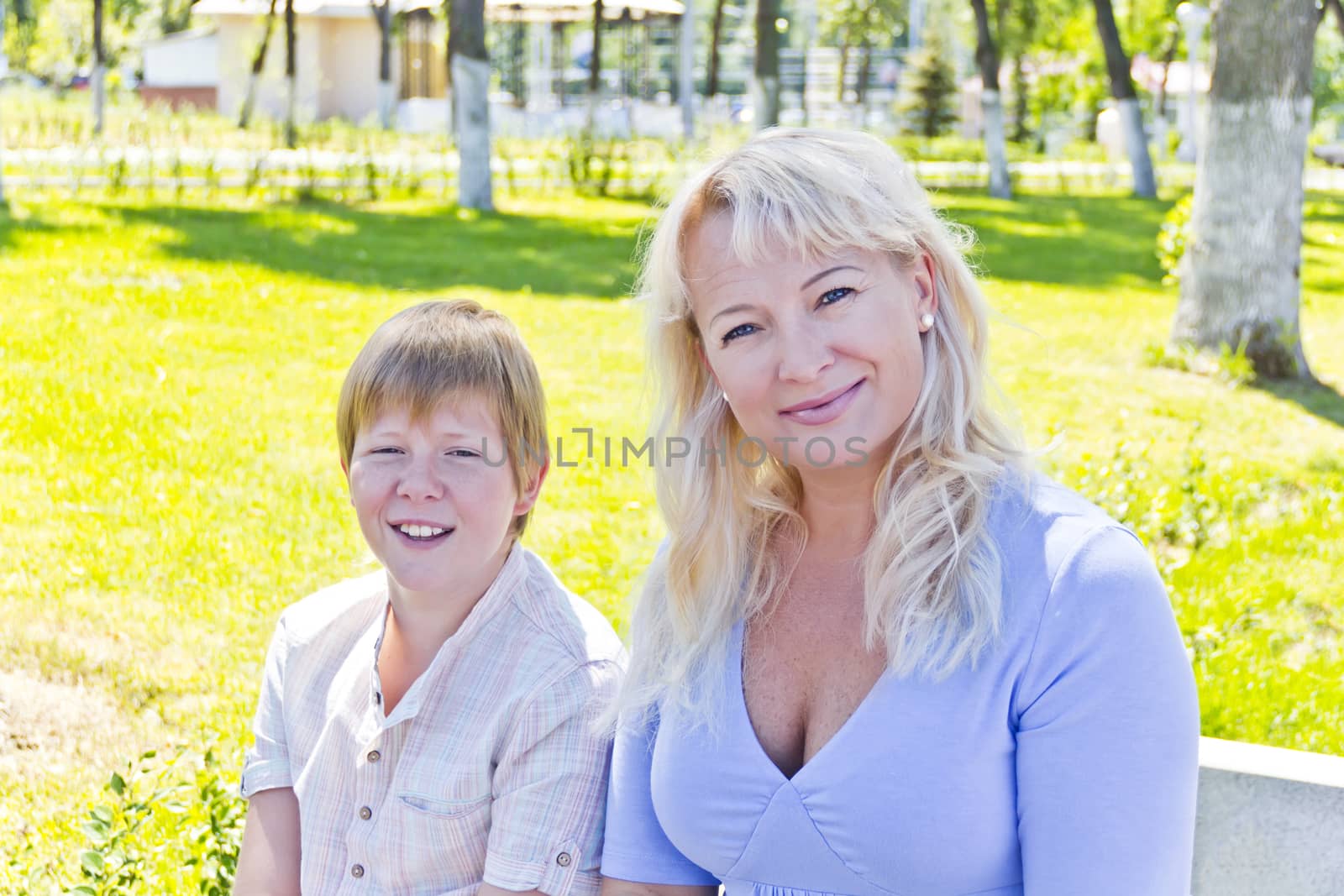 Blond woman and son smiling in the summer by Julialine