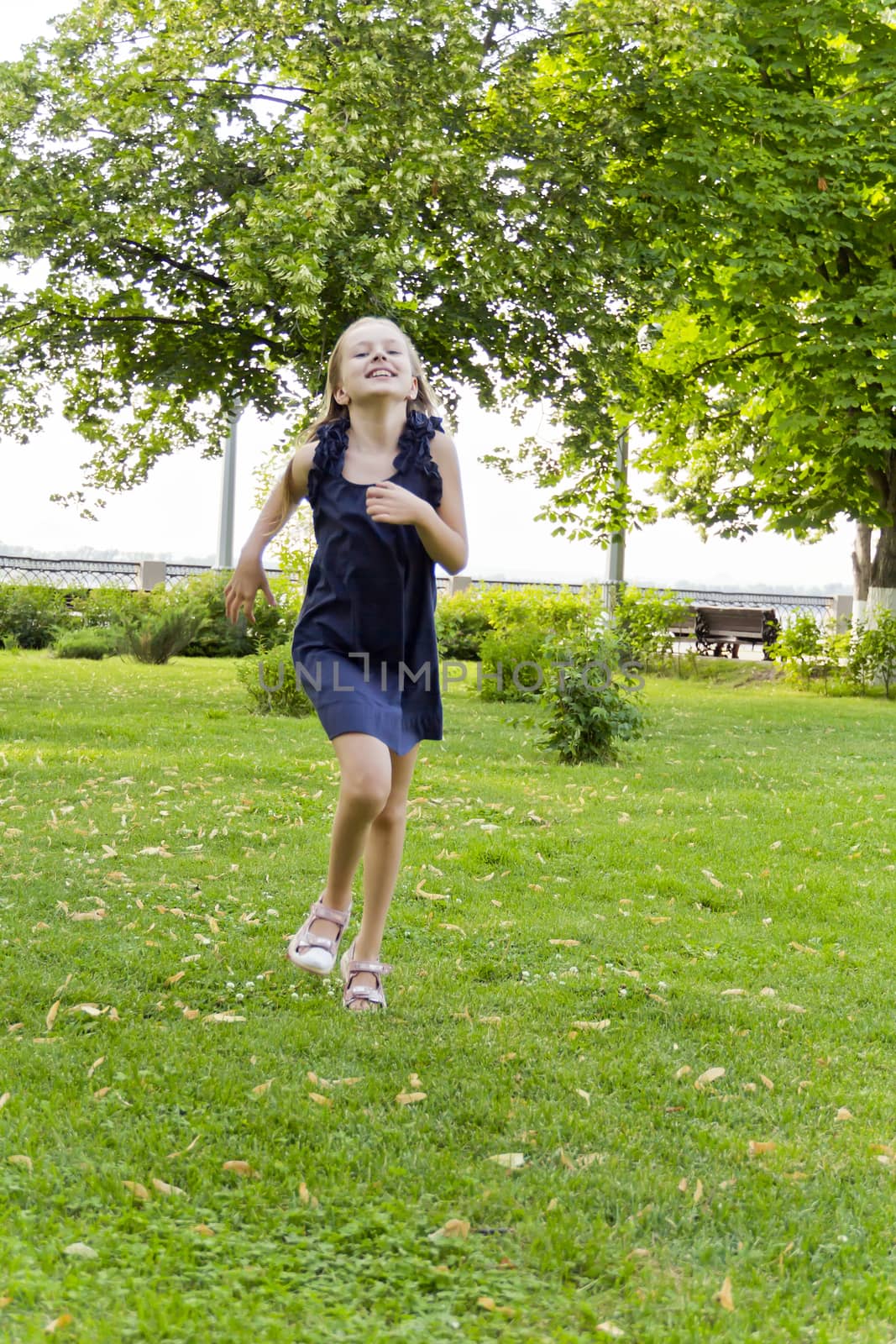 Cute running European girl with disheveled hair in green park