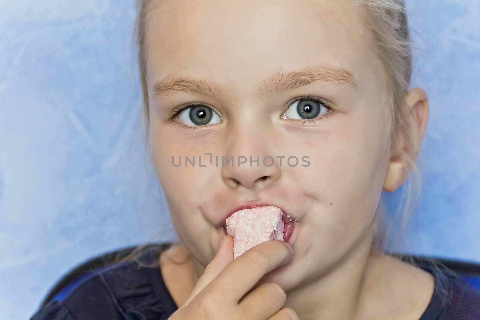 Cute eating girl with blond hair on blue background