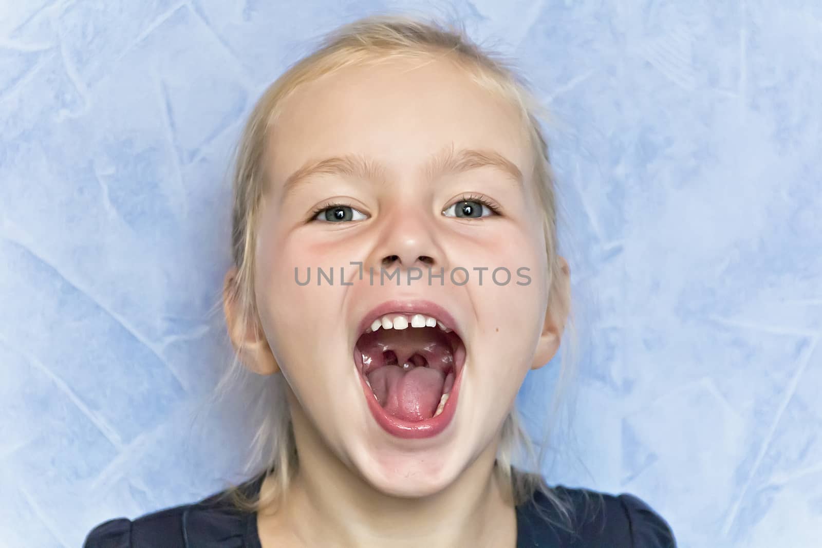 Cute cry girl with blond hair with open mouth