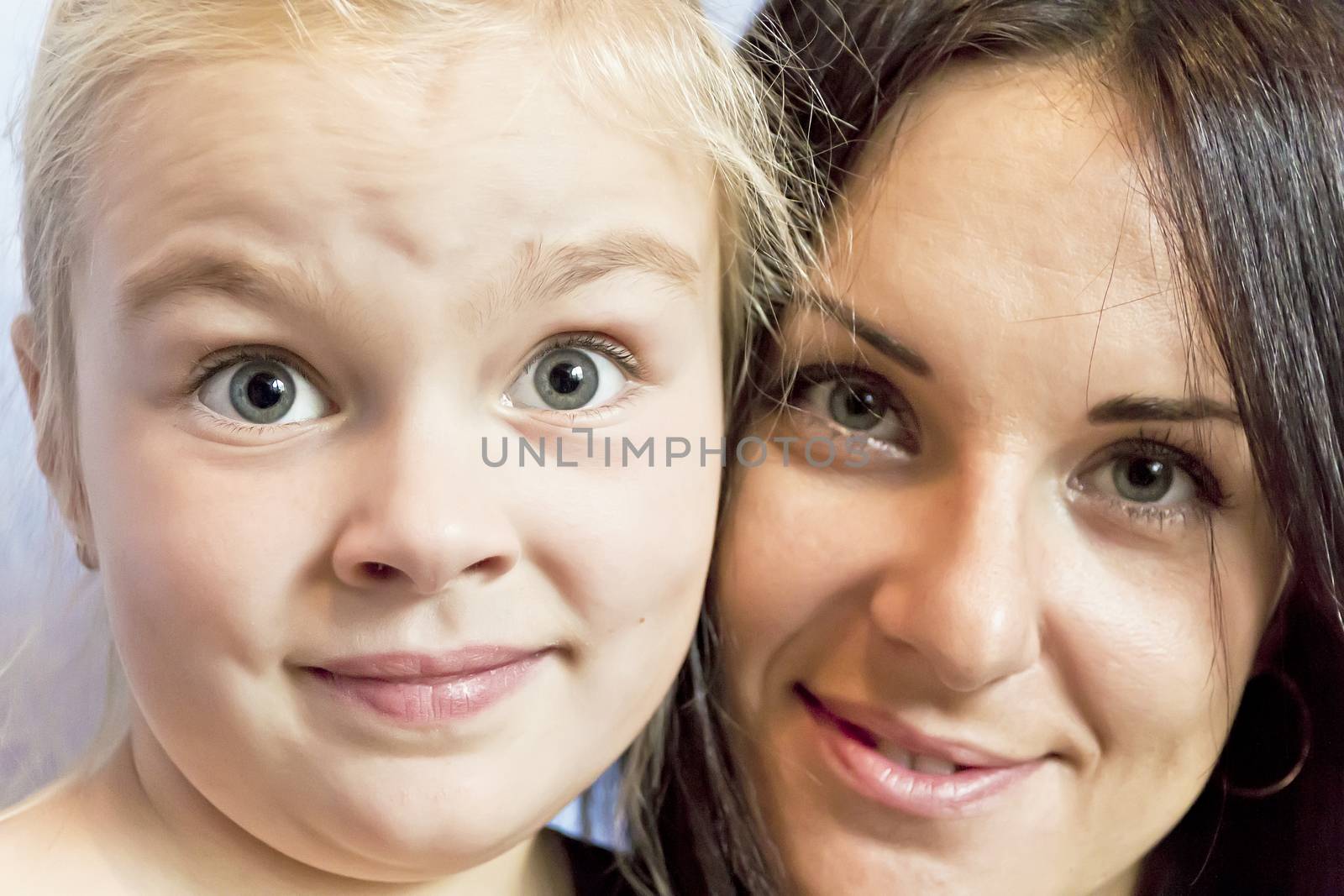 Portrait of cute blond daughter with brunette mother