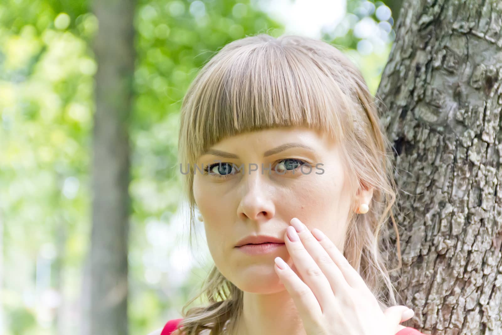 Portrait of thinking girl with blue eyes on green wood background